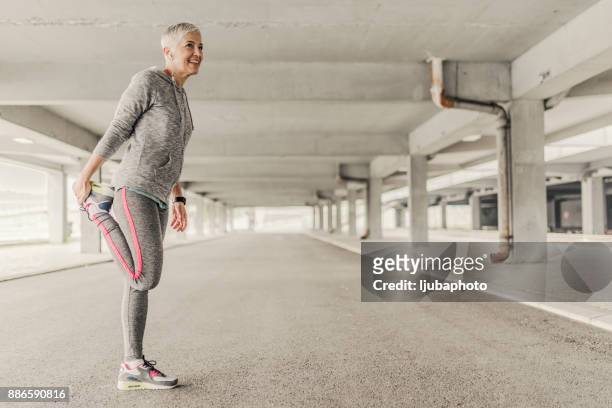 sportswoman de estiramiento - older woman legs fotografías e imágenes de stock