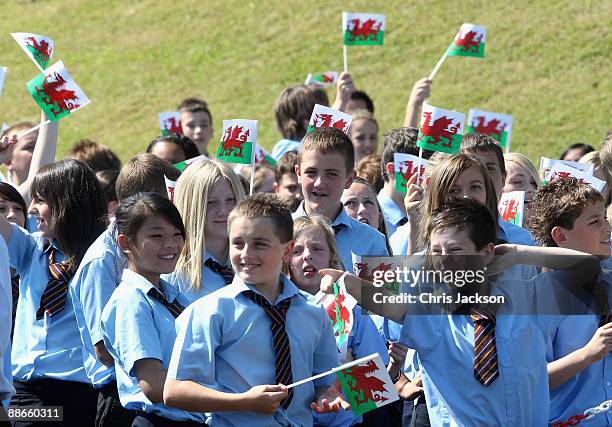 Children wave Welsh Flags as HRH Prince Charles, Prince of Wales makes a speech during a visit to Treorchy Comprehensive School on June 23, 2009 in...