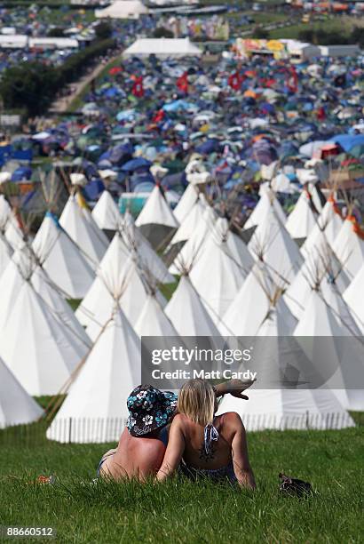 Two festival goers take in the view of the tipi field as music fans start to arrive at the Glastonbury Festival site at Worthy Farm, Pilton on June...