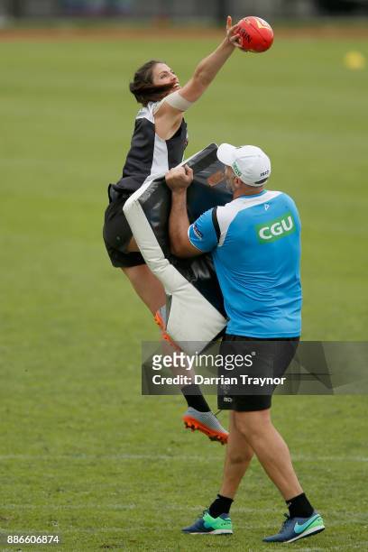 Eliza Hynes goes through some ruck drills with Collingwood assistant coach Anthony Rocca during a Collingwood Magpies men's and women's joint AFL...