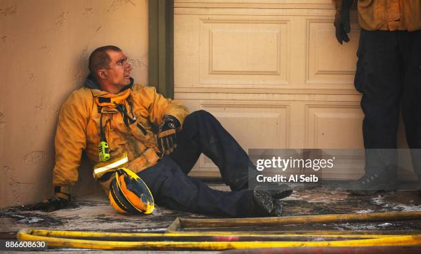 Ventura County Firefighter Aaron Cohen catches his breath after fighting to save multi-million dollar homes along Cobblestone Drive near Foothill...