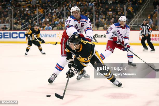 Sidney Crosby of the Pittsburgh Penguins battles for the puck with Ryan McDonagh of the New York Rangers during the second period at PPG PAINTS Arena...