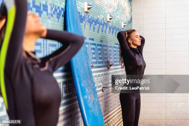 friends cleaning surf boards at the end of a long day on the beach in california - manhattan beach stock pictures, royalty-free photos & images