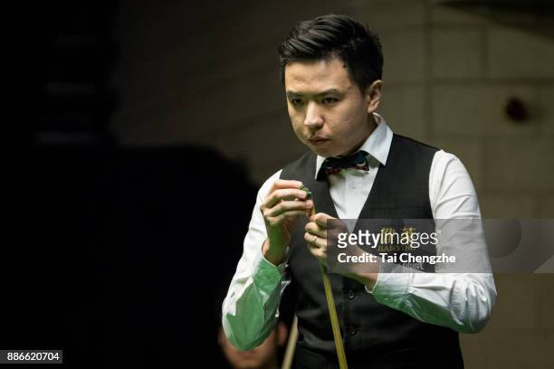 Xiao Guodong of China chalks the cue during his third round match against Noppon Saengkham of Thailand on day 9 of 2017 Betway UK Championship at...