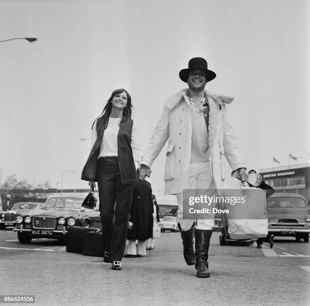 British actor Oliver Reed and girlfriend, ballet dancer Jackie Daryl, leaving Heathrow airport, London, UK, 17th May 1971.