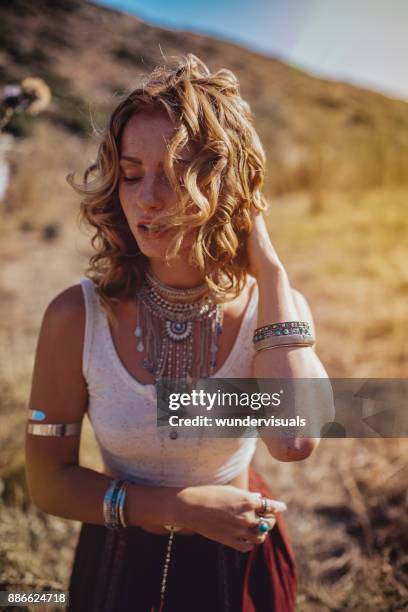 beautiful young redhead woman in boho style standing in field - music festival field stock pictures, royalty-free photos & images