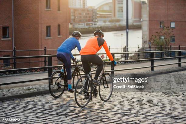 two senior men on racing bikes - active seniors biking stock pictures, royalty-free photos & images