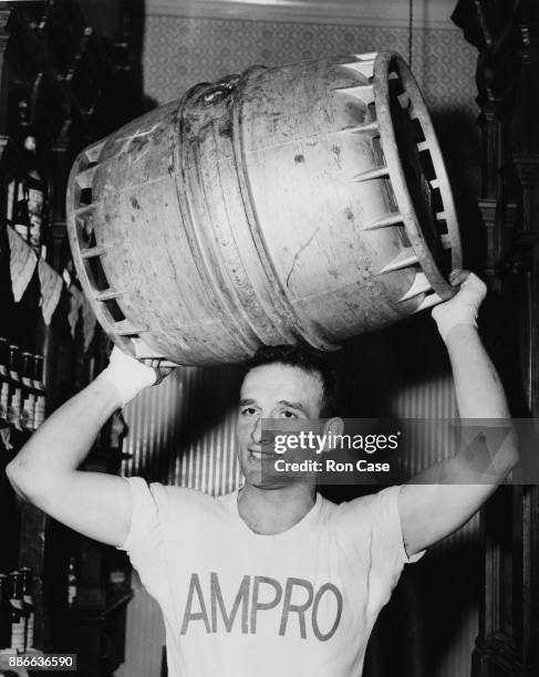 British boxer Joe Lucy , the lightweight champion of Great Britain, keeps fit by carrying barrels of beer at his pub, the 'Thomas a Beckett' on the...