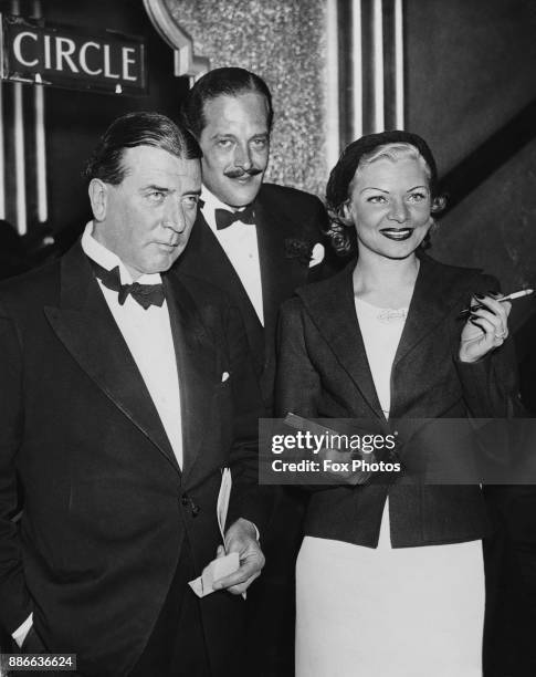 American actress Claire Luce attends the premiere of the film 'A Woman Alone' at the London Pavilion, accompanied by her husband Clifford W. Smith...