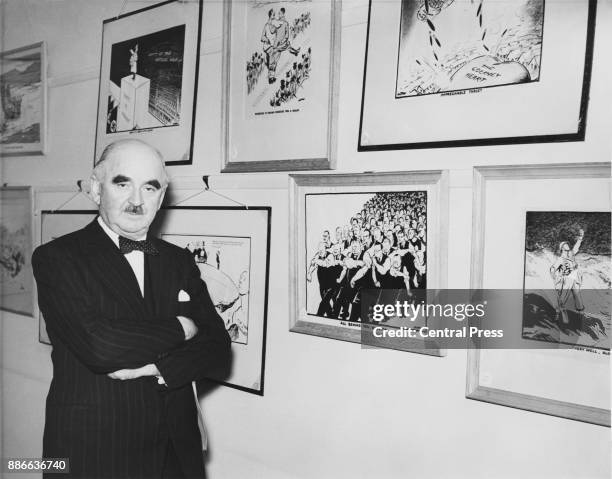 New Zealand political cartoonist David Low with some of his wartime works, circa 1960.
