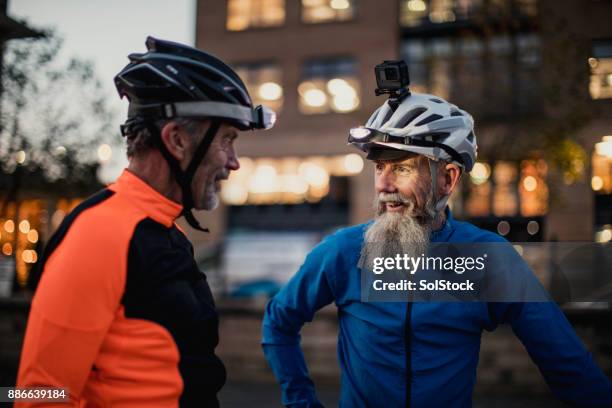 due ciclisti più anziani uno che indossa una fotocamera del casco - lampada da testa foto e immagini stock