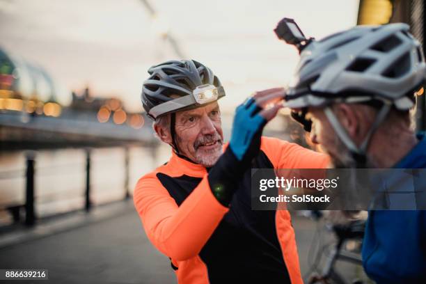 adjusting a cycle helmet light - cycling helmet stock pictures, royalty-free photos & images