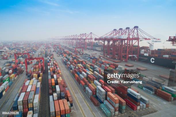 aerial view of shanghai yangshan deepwater port which is a  industrial port with containers in sunset - shanghai stockfoto's en -beelden