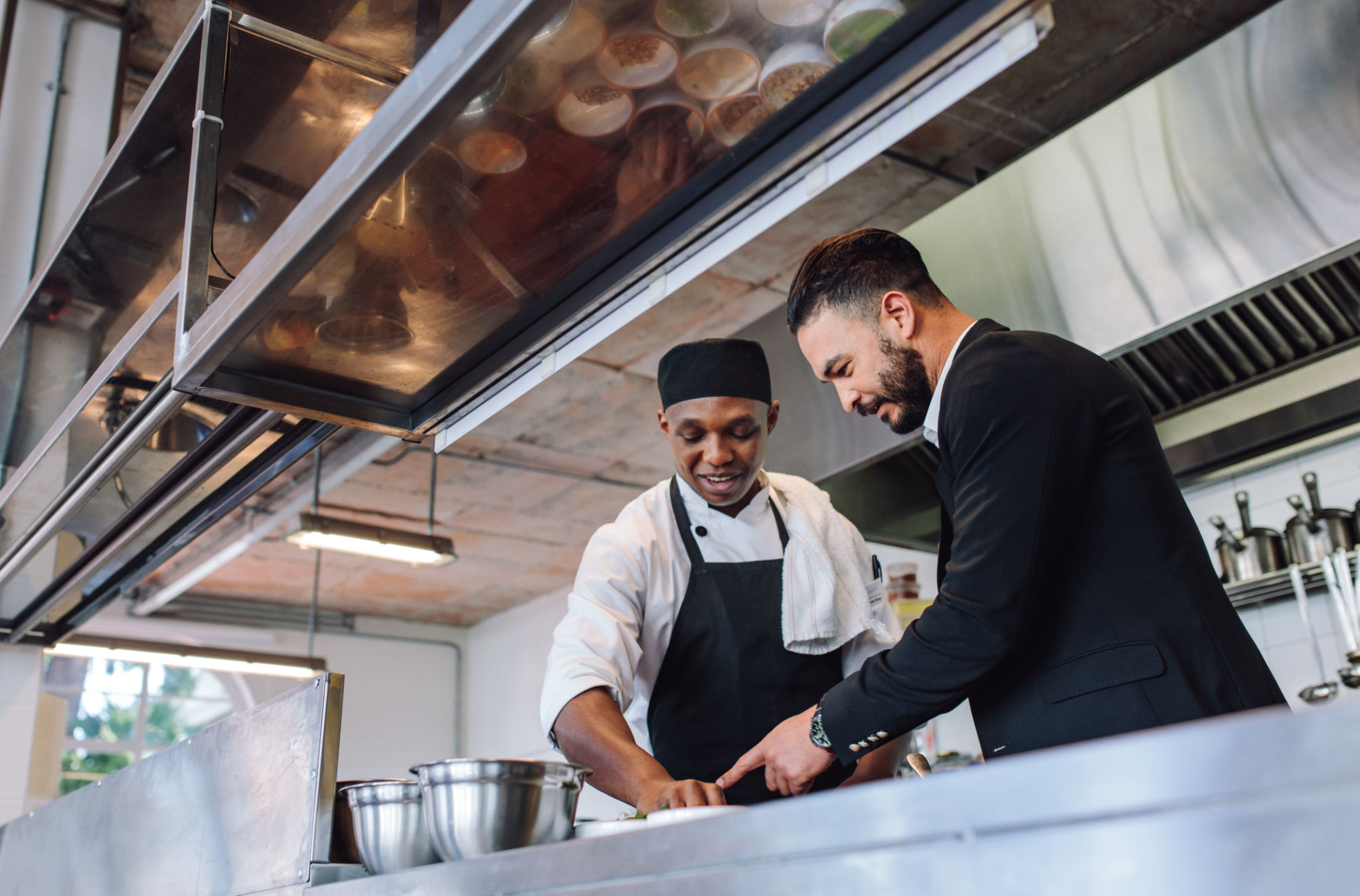 Restaurant manager with chef in kitchen Restaurant manager with chef in kitchen