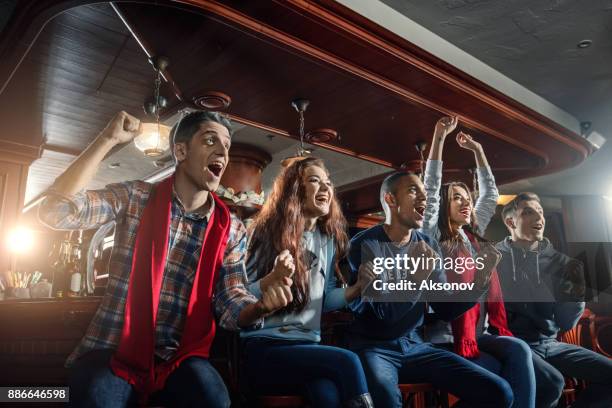 fans at the bar joyfully screaming and celebrate victory of their favorite sports team - tv audience stock pictures, royalty-free photos & images