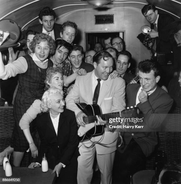 American rock and roll musician Bill Haley and his band Bill Haley & His Comets entertain their fellow-travellers in a cramped railway carriage en...