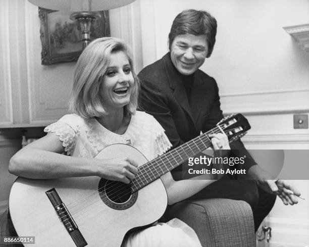 American actor Charles Bronson listens to his wife, actress Jill Ireland , play the guitar in London, 9th January 1969. Bronson is in the UK to star...