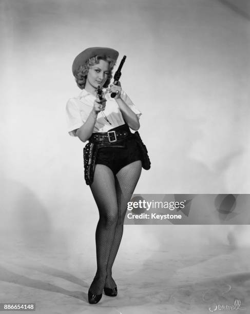 French actress Gaby Bruyère poses as a cowgirl, USA, circa 1950.