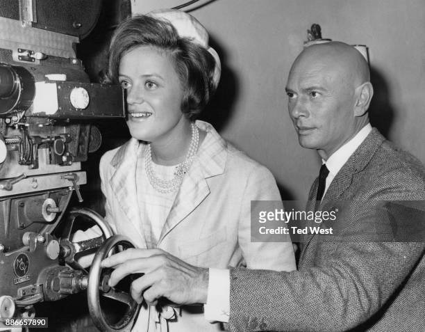 Russian-born actor Yul Brynner demonstrates a film camera to Princess Muna al-Hussein , the wife of King Hussein of Jordan, during her visit to...