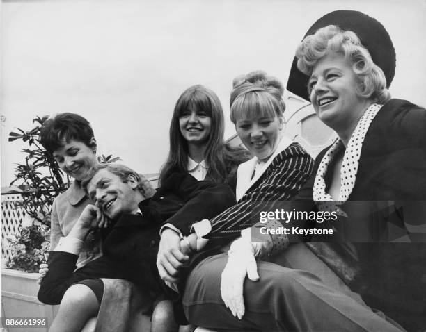 English actor Michael Caine, star of the film 'Alfie', surrounded by his female co-stars, 5th July 1965. From left to right, the actresses are Vivien...