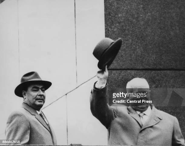 Leonid Brezhnev and Nikita Khrushchev wave from Lenin's Tomb in Moscow after the announcement that Khrushchev was resigning as First Secretary of the...