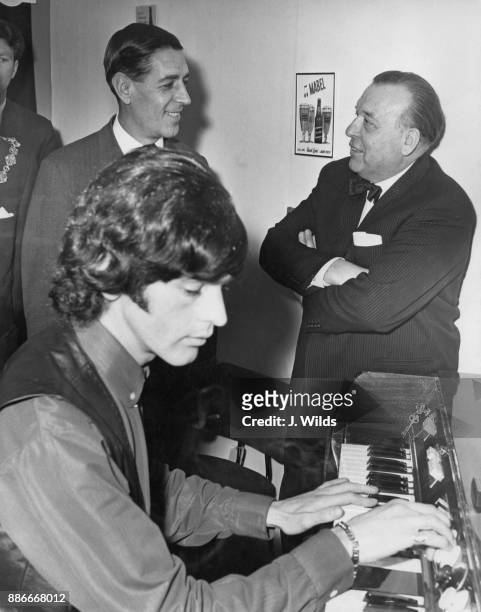 Edward du Cann , the MP for Taunton and Conservative Party chairman, watches musician Geoff Unwin on the Mellotron, explained by bandleader Eric...