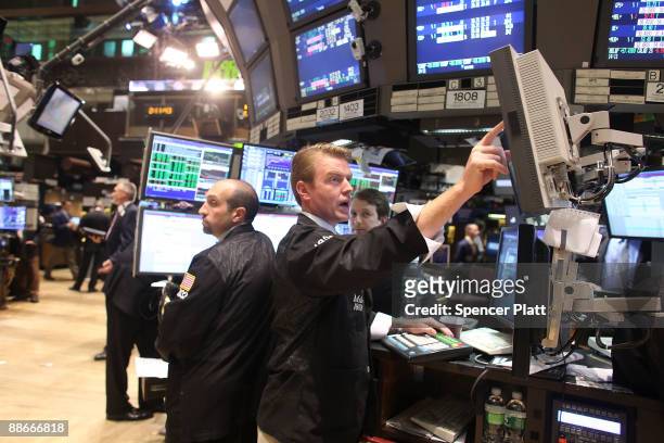 Traders work on the floor of the New York Stock Exchange as the Federal Reserve announces that it will be keeping its key interest rate near zero on...