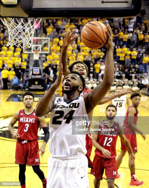 Kevin Puryear of the Missouri Tigers drives toward the basket as Dalonte Brown of the Miami Redhawks defends during the game at Mizzou Arena on...