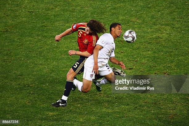Carles Puyol of Spain and Charlie Davies of the USA vie for a header during the FIFA Confederations Cup Semi Final match between Spain and USA at...