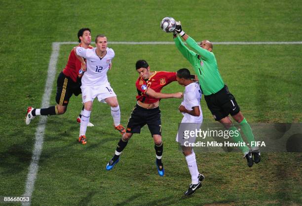 Goalkeeper Tim Howard punches the ball clears under pressure from David Villa27 of Spain during the FIFA Confederations Cup Semi Final between Spain...