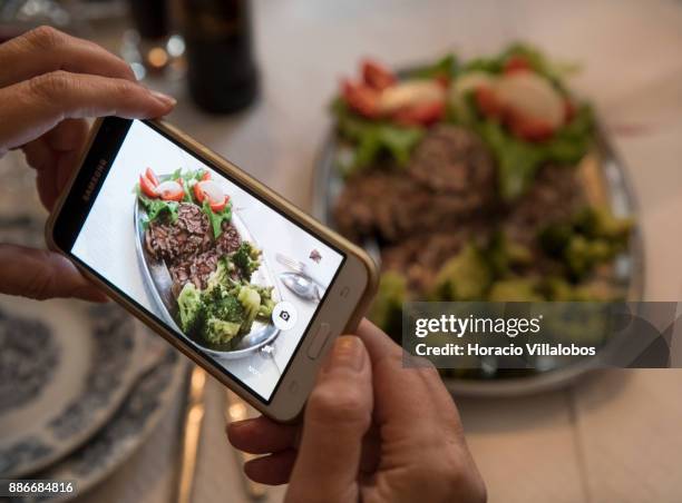 Participant takes a picture of "Bucho de Coja com Broculos e Salada" at lunch in Restaurante o Fontinha during Gastronomic FAM Tour on November 28,...