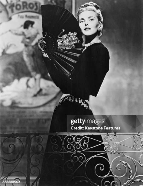 American actress Anita Colby wearing a Spanish-style ensemble in black velvet, with a gold tasseled cummerbund, May 1946.