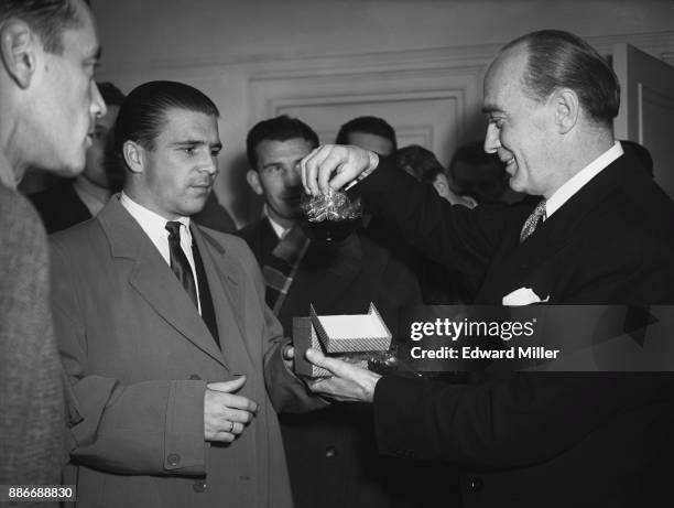 Mr A. Collombin, the manager of the Cumberland Hotel, presents a souvenir ashtray to Ferenc Puskas , captain of the Hungarian football team, during a...