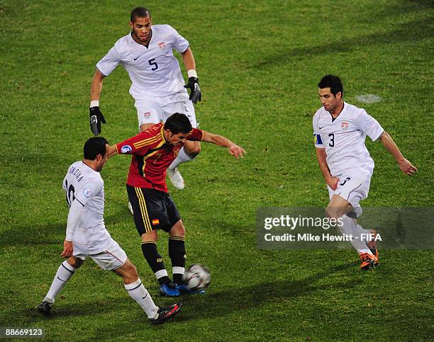 David Villa of Spain is surrounded by Landon Donovan, Oguchi Onyewu and Carlos Bocanegra of USA during the FIFA Confederations Cup Semi Final between...