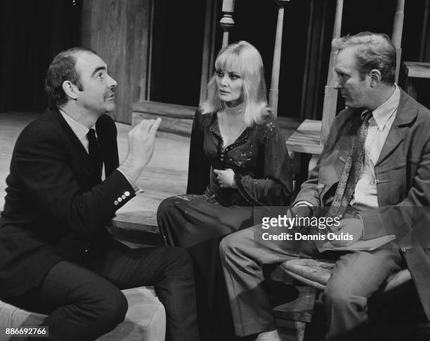 Scottish actor Sean Connery talks to his wife, actress Diane Cilento and actor Robert Hardy during a break in rehearsals for 'I've Seen You Cut...