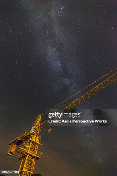 low angle view of cranes and milky way - work sites night stock pictures, royalty-free photos & images