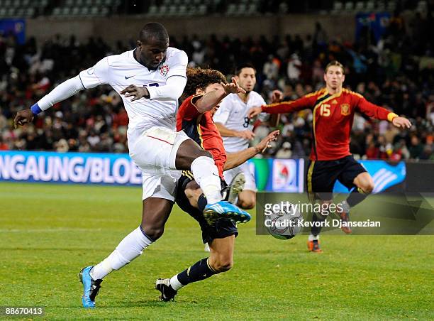 Jozy Altidore of USA takes a shot on goal against Carles Puyol of Spain during the FIFA Confederations Cup Semi Final match between Spain and USA at...
