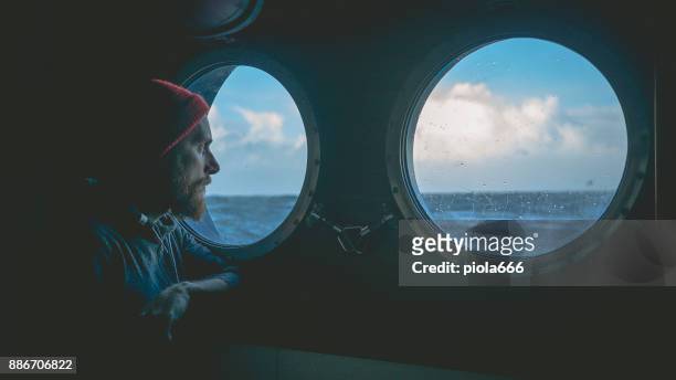 在舷窗上的一艘船在波濤洶湧的大海的人 - 船員 個照片及圖片檔