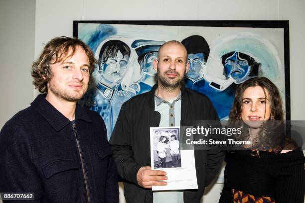 Jasper, Josh and Eliza May, sons and daughter of the late Jonathan Hague, pose with one of their father’s paintings of the Beatles at the opening of...