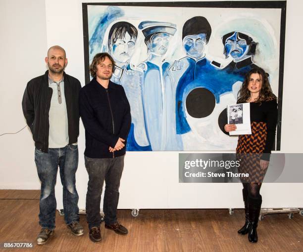 Jasper, Josh and Eliza May, sons and daughter of the late Jonathan Hague, pose with one of their father’s paintings of the Beatles at the opening of...