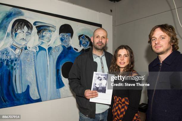 Jasper, Josh and Eliza May, sons and daughter of the late Jonathan Hague, pose with one of their father’s paintings of the Beatles at the opening of...