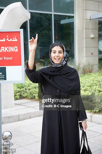 woman flagging down a taxi, dubai, uae - dubai cab stock pictures, royalty-free photos & images