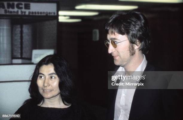 Former member of The Beatles pop group John Lennon with his wife Yoko Ono at Heathrow Airport, London as they pass through from Trinidad on their way...