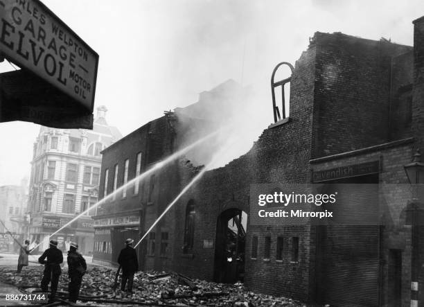 Firemen dampening down Mateer & Nelson on Chapel Street, Hull following an overnight air raid by the Luftwaffe on the city, 8th May 1941.