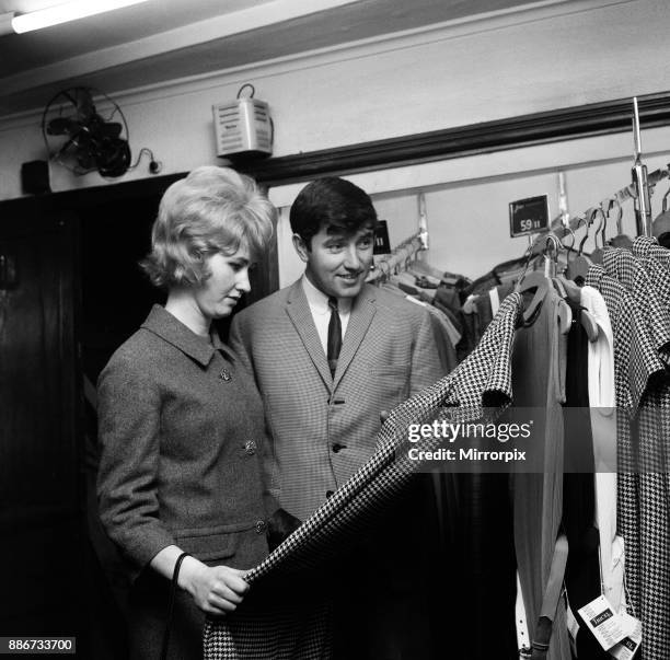 Comedian Jimmy Tarbuck, aged 23, with his wife Pauline, also 23, on a shopping spree before returning home to Liverpool, 28th October 1963.