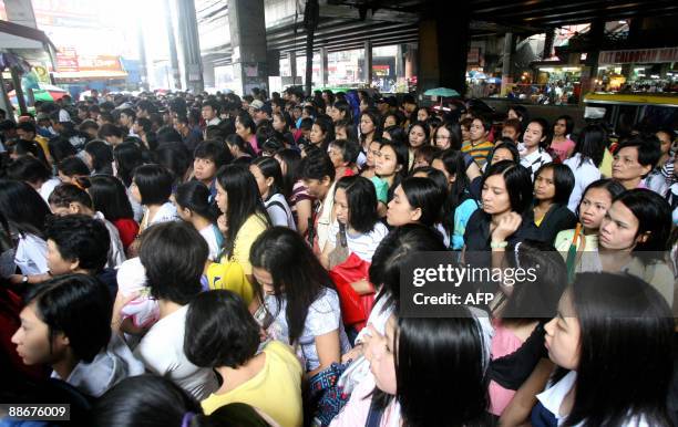 Passengers queue up at a train station in Manila on June 25, 2009 after services were interrupted because of rains caused by Typhoon Nangka. Nangka...