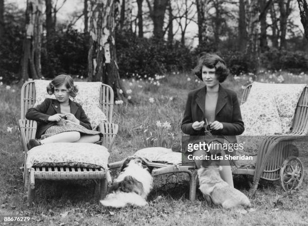 Princess Elizabeth and her younger sister Princess Margaret Rose knitting for the forces in the grounds of the Royal Lodge in Windsor Great Park,...