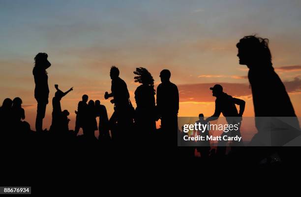 People gather to watch the sunset on a hill above the tipi field as music fans start to arrive at the Glastonbury Festival site at Worthy Farm,...