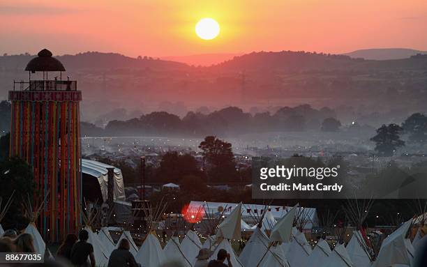 People gather to watch the sunset on a hill above the tipi field as music fans start to arrive at the Glastonbury Festival site at Worthy Farm,...