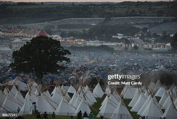 Mist rises over tents as the sun sets as music fans start to arrive at the Glastonbury Festival site at Worthy Farm, Pilton on June 24, 2009 in...